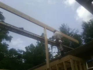 Carpenter setting a ridge beam over a new addition frame — Ice Dam Removal by Roofing Brothers in Old Station