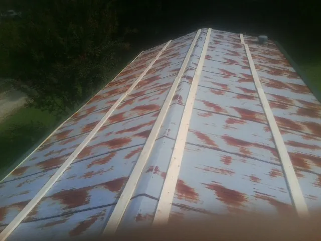 Rusted metal roof panels with new wood purlins before replacement — Storm Damage Roof Repair in Old Station by Roofing Brothers