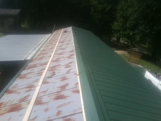 Old rusted panels beside newly installed green metal roofing — Wind Damage Roof Repair by Roofing Brothers in Old Station