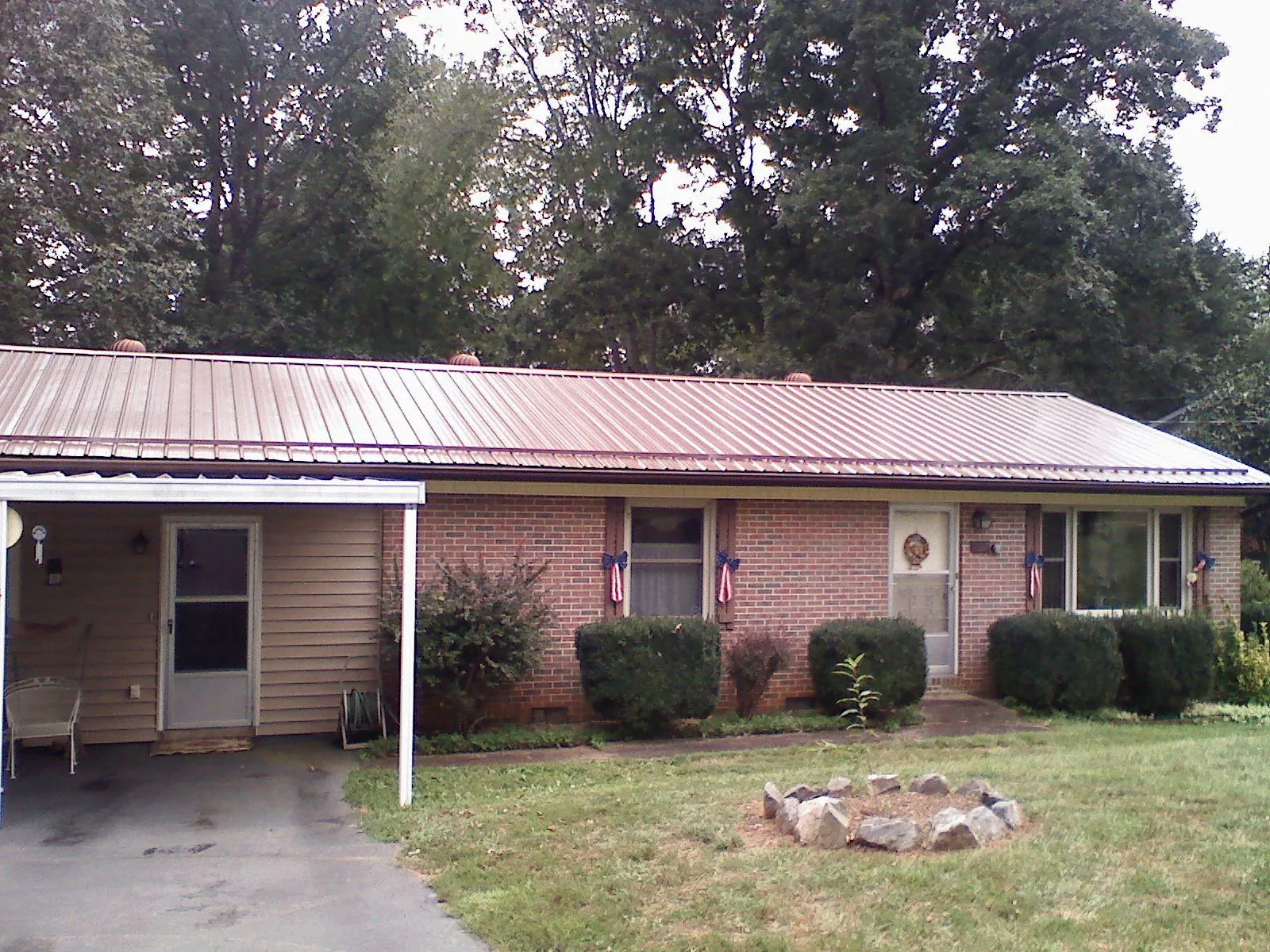 Bronze metal roof and carport on a brick ranch home — Roof Repair work by our crew in Old Station